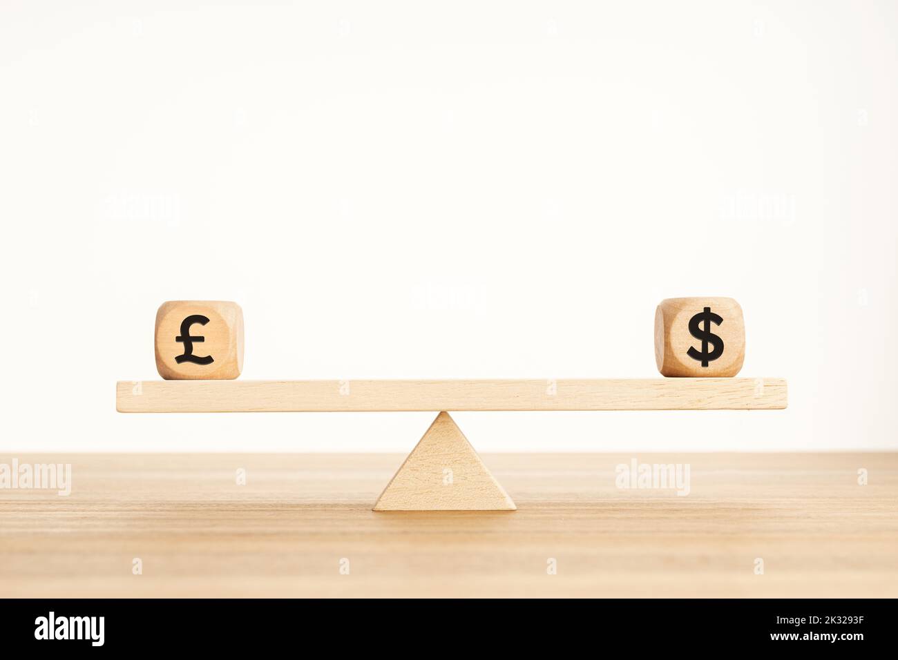 Pound and dollar parity concept. Sterling and US dollar symbol on wooden cube shape on a seesaw. Copy space Stock Photo