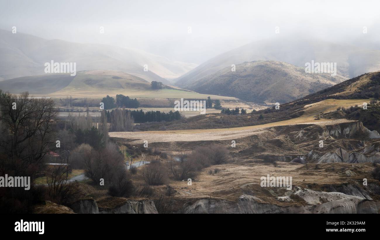 Rolling hills in fog at St Bathans, Central Otago. Stock Photo