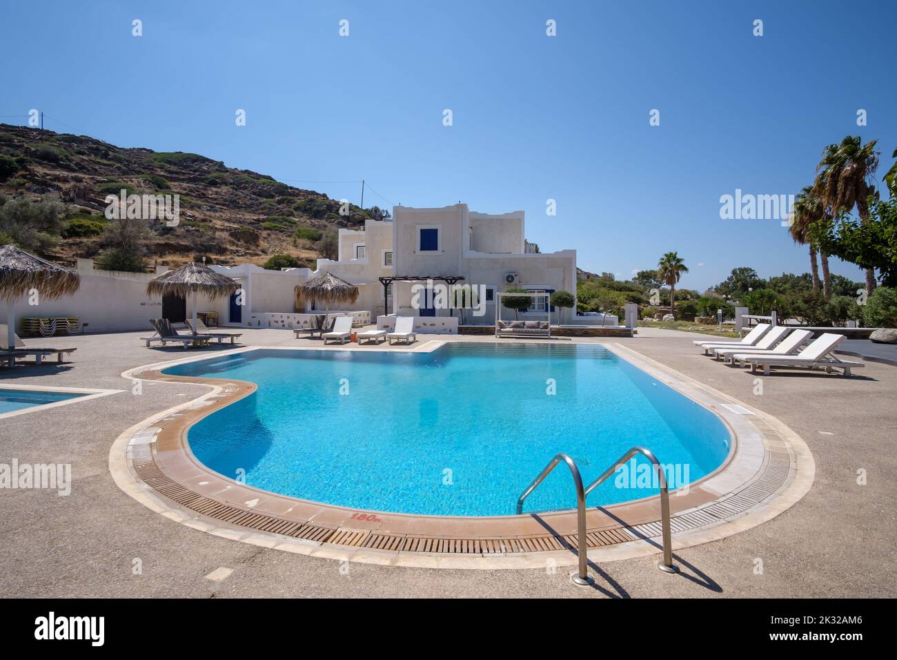 Ios, Greece - September 13, 2022 : Panoramic view of a beautiful luxury hotel with swimming pool,  sun beds and sun umbrellas in Ios Greece Stock Photo