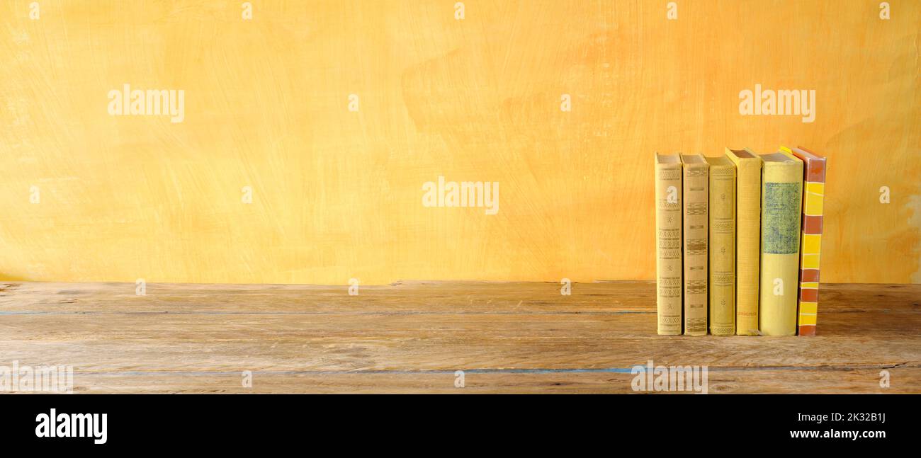 Row of yellow books on yellow background, inspiration,reading, education, literature  concept,  panoramic, large free copy space Stock Photo
