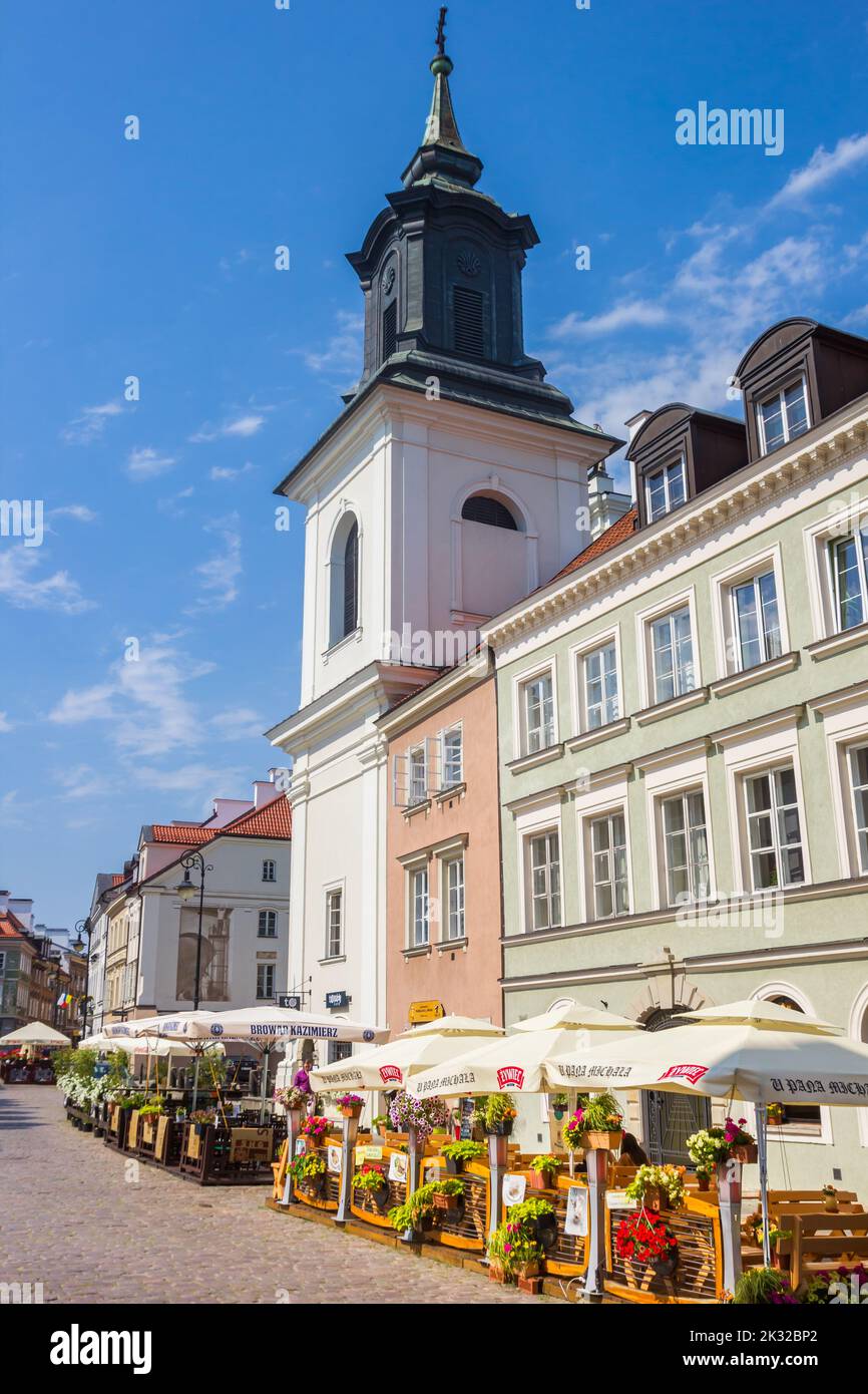 Restaurants in front of a white church tower in Warsaw, Poland Stock Photo
