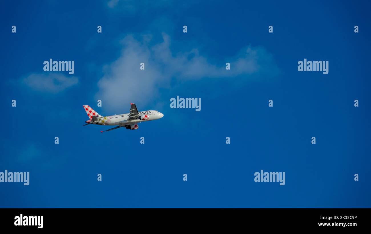Palma, Spain; August-24, 2022: Plane of the Volotea airline company flying in the blue sky Stock Photo