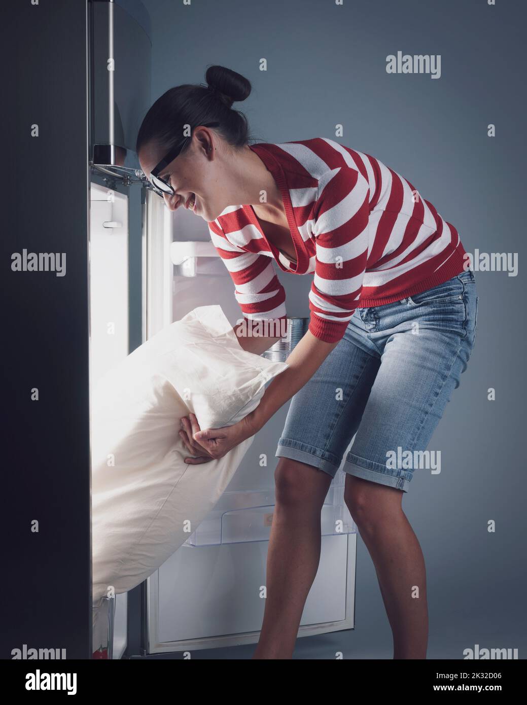 https://c8.alamy.com/comp/2K32D06/happy-woman-putting-her-bed-pillow-in-the-fridge-hot-weather-and-heatwave-concept-2K32D06.jpg