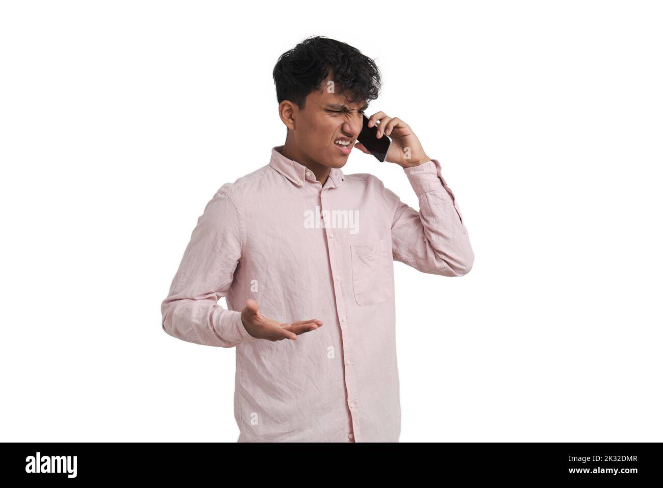 Young peruvian man angry and shrugging speaking on the phone, isolated. Stock Photo
