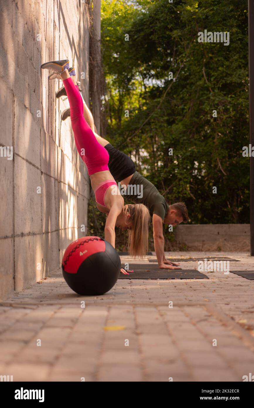 Couple is training together while holding their body upside down on the ...