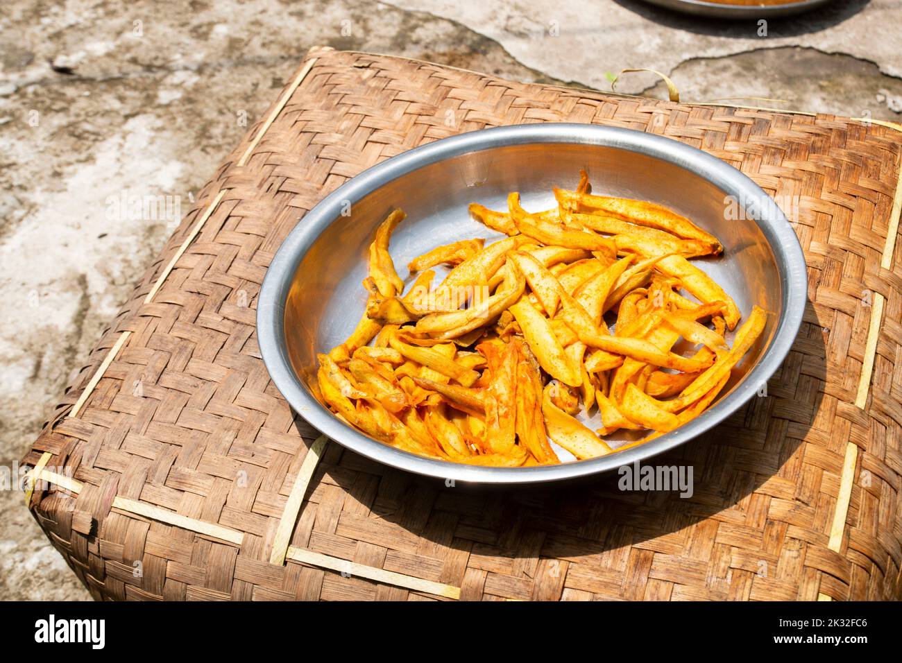 mango slices under the sun to dry it for making mango powder or pickle. Natural food preservation. Stock Photo