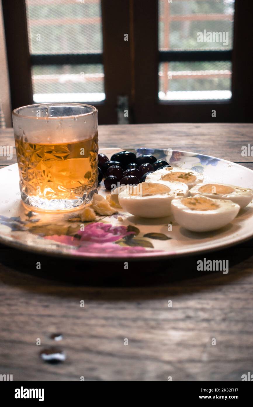 Vintage Whiskey Glass served with boiled eggs and black grapes. Uttarakhand India. Stock Photo