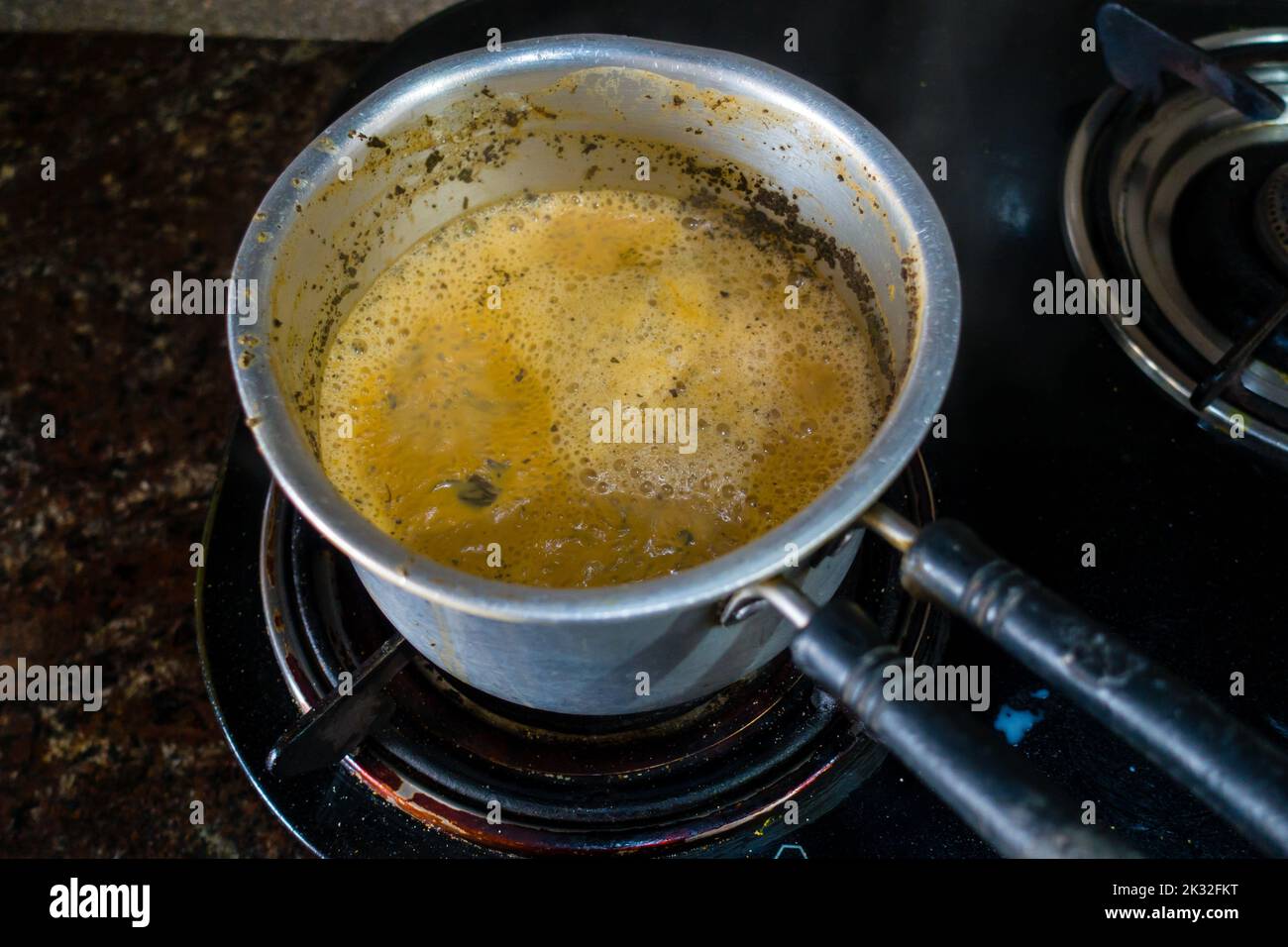 Milk Tea preparation on a gas stove in an Indian House hold Kitchen. Table top view. Uttarakhand india. Stock Photo