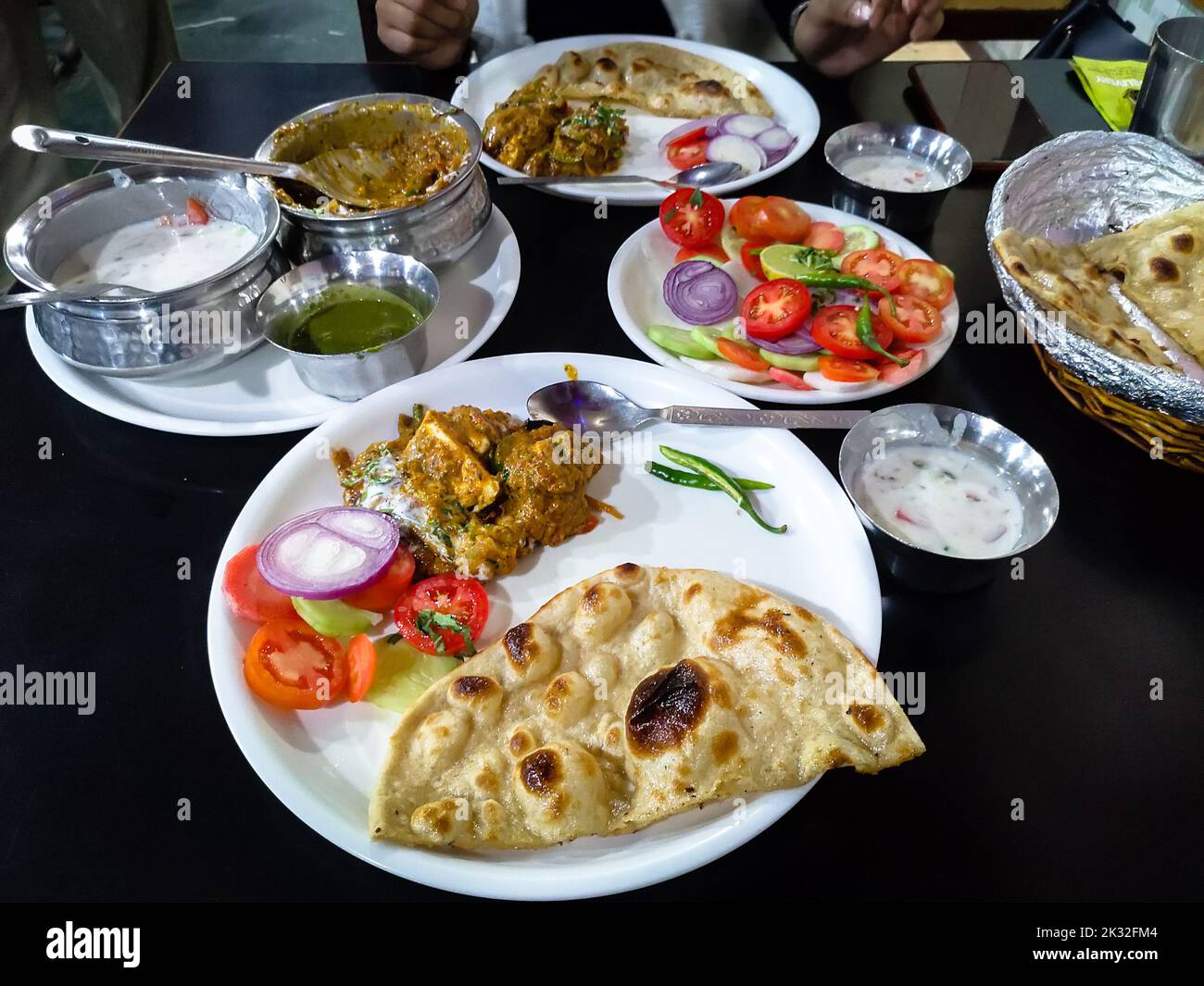 Indian Full course meal served with kadhai paneer,Indian butter roti, spiced curd ,green salad. Restaurant in New Delhi India. Stock Photo