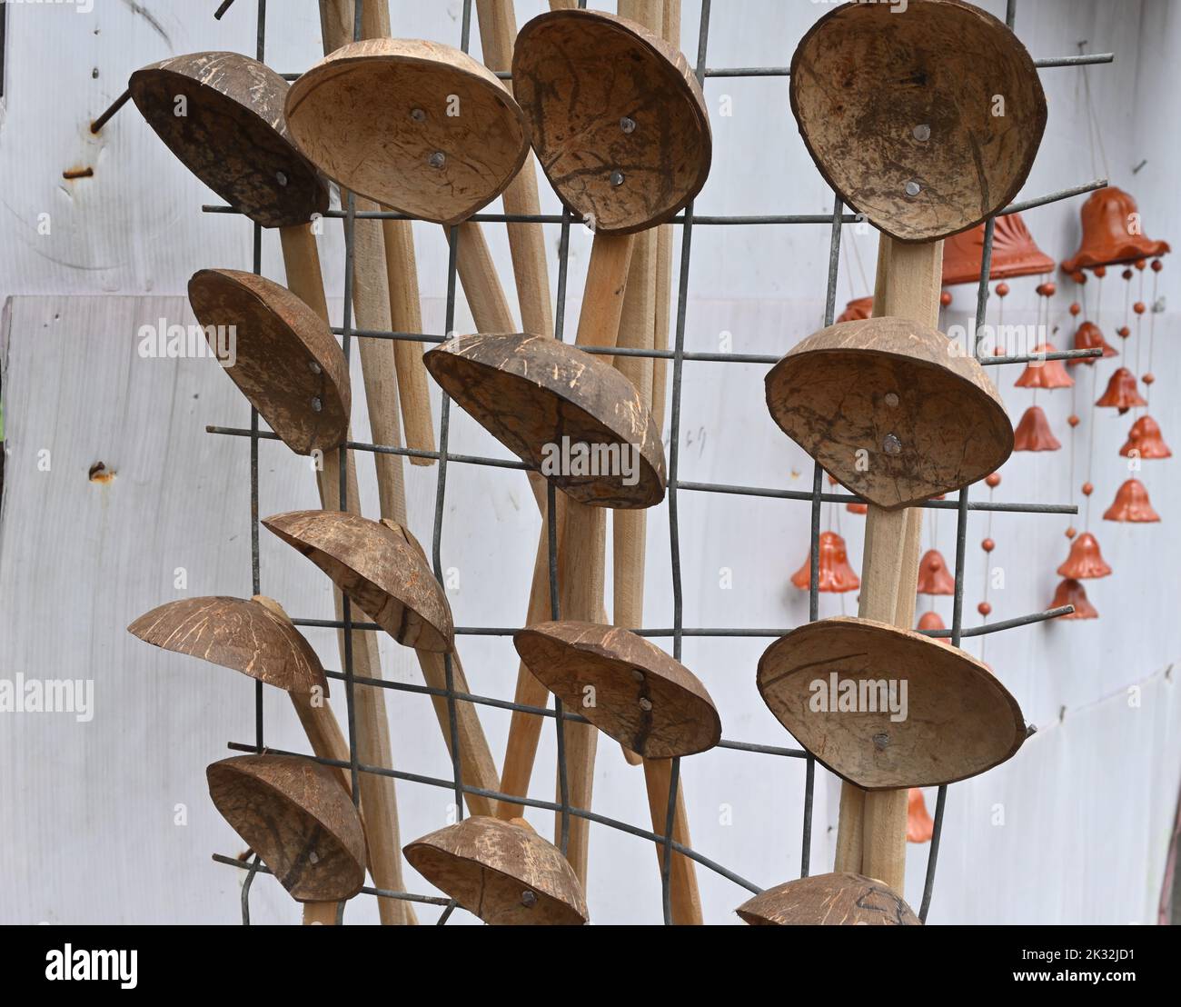 Handmade Coconut shell spoons hang on an iron grid for sell Stock Photo