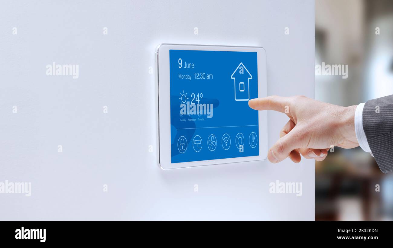 Man checking a smart home touch screen control panel home automation