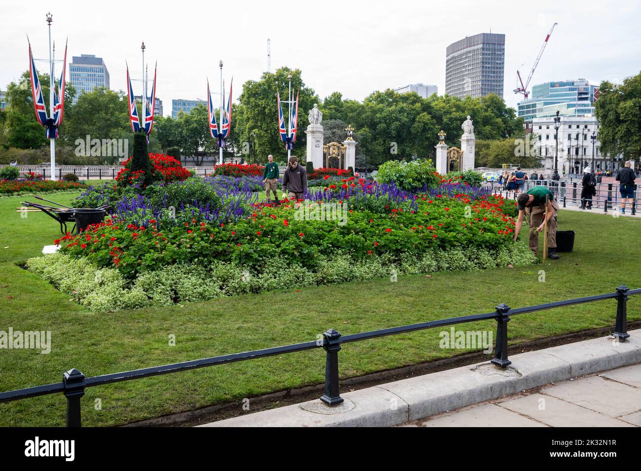 Gardeners plant flowers outside Buckingham Palace In London after the