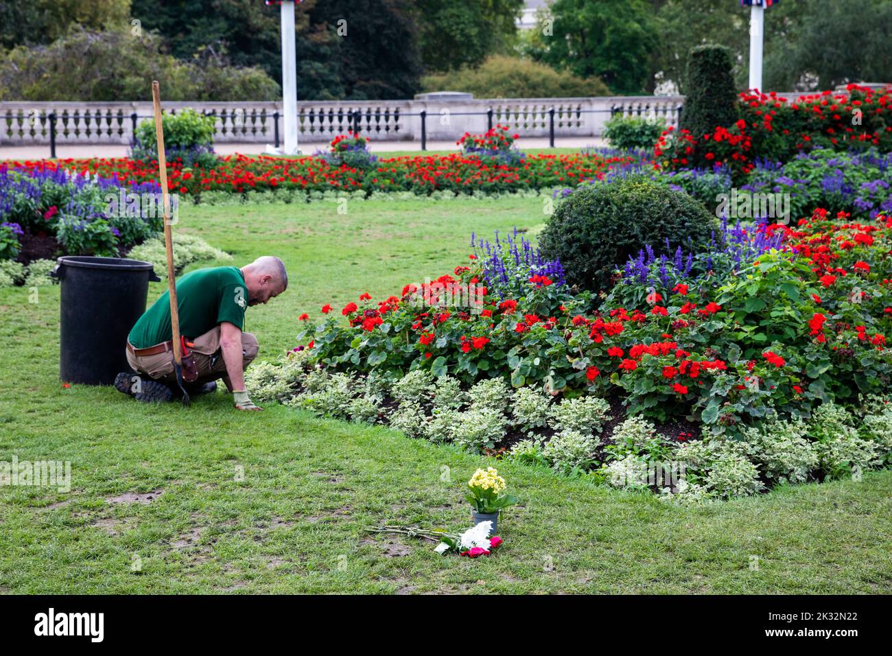 Gardeners plant flowers outside Buckingham Palace In London after the