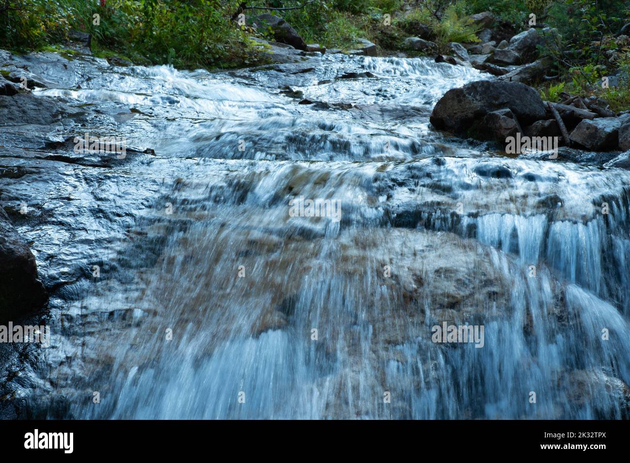 A closeup of water flowing along the waterfall Stock Photo - Alamy