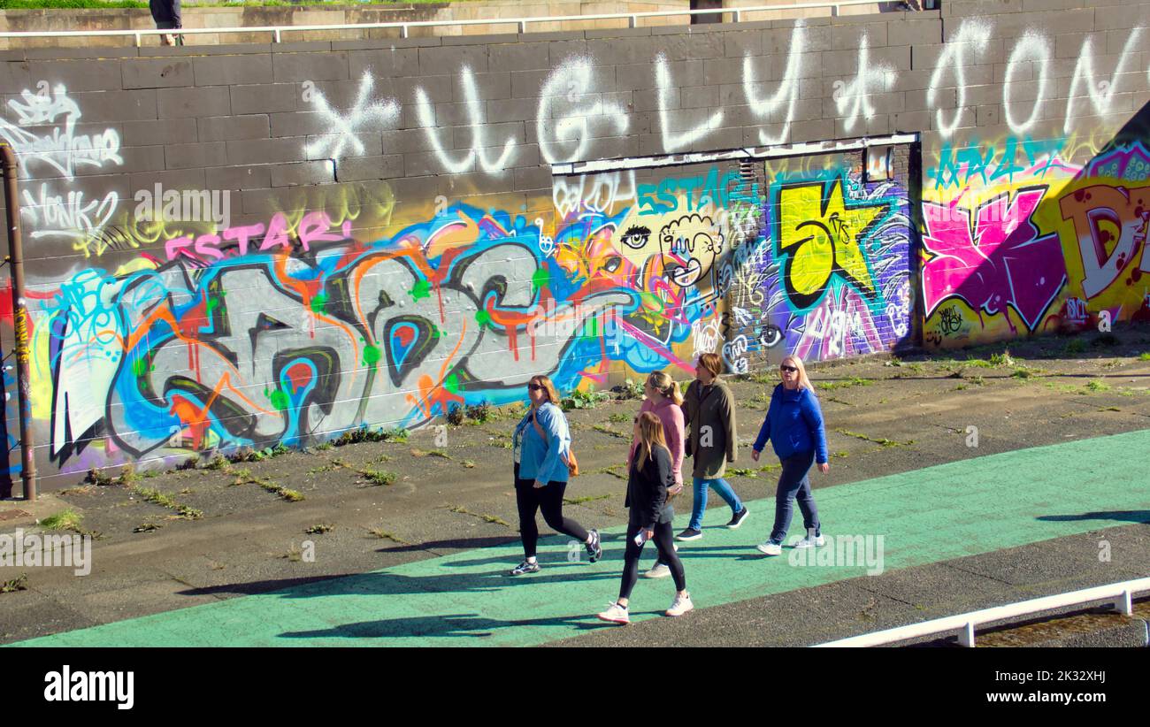 Glasgow, Scotland, UK 24th September,  2022. UK Weather: Hot and Sunny in the city saw locals an tourists take to the streets.. The clyde walkway at the side of the river has turned into a riverside grafitti art gallery.  Credit Gerard Ferry/Alamy Live News Stock Photo