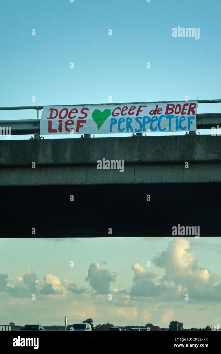 Banner above highway with text, be sweet give the farmer perspective. Dutch farmers protest against the plans of the government forced shrinking of Stock Photo