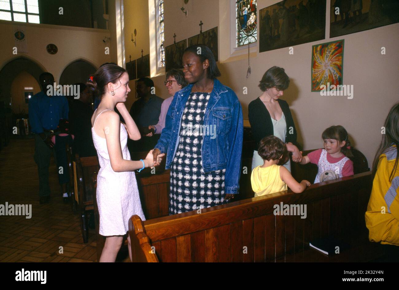 Congregation Shaking Hands after Communion Sign of Peace St Joseph's Church Roehampton London England Stock Photo