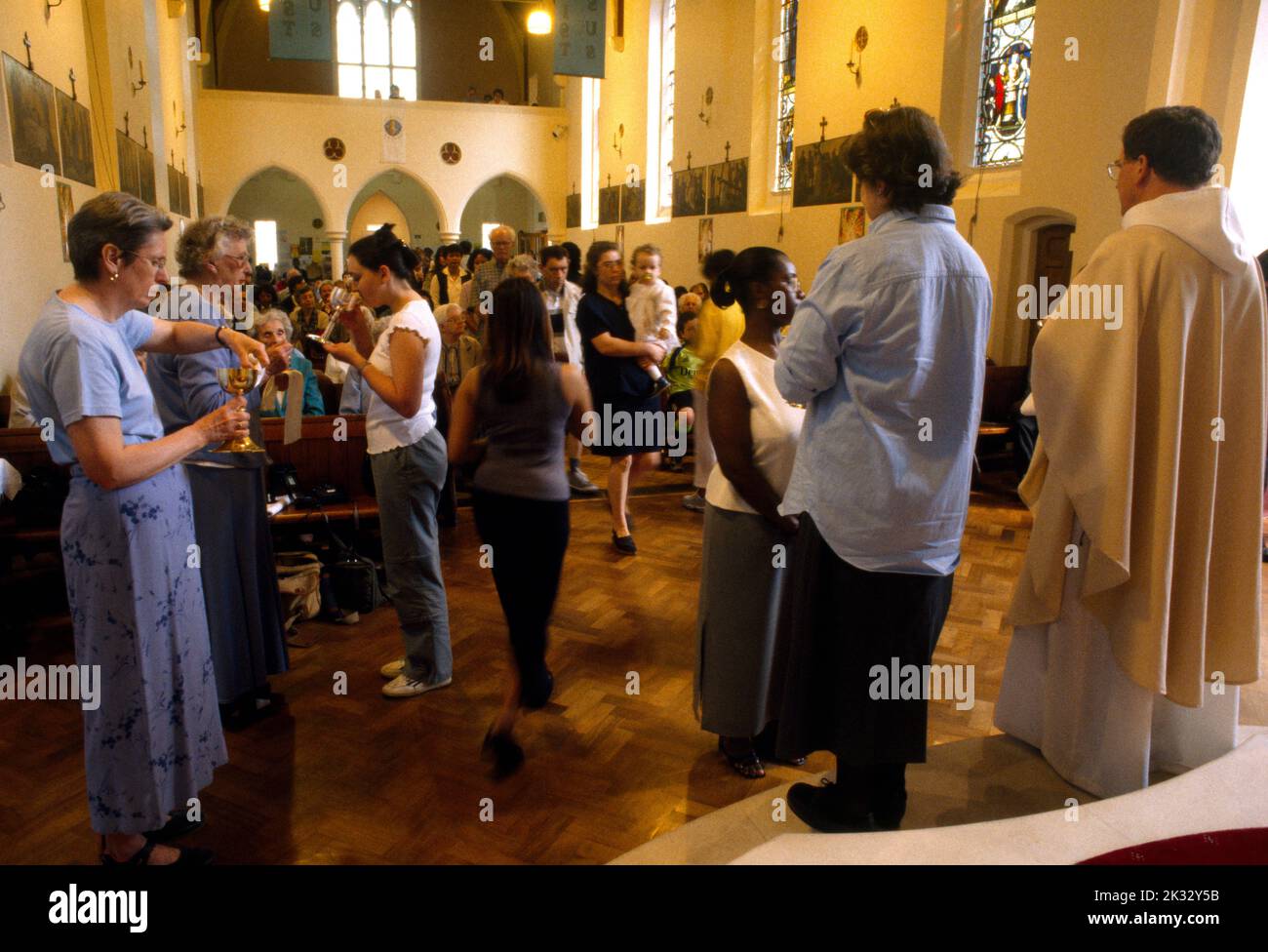 People Receiving the Sacramental Wine in Chalice at St Joseph's Church Roehampton London England Stock Photo