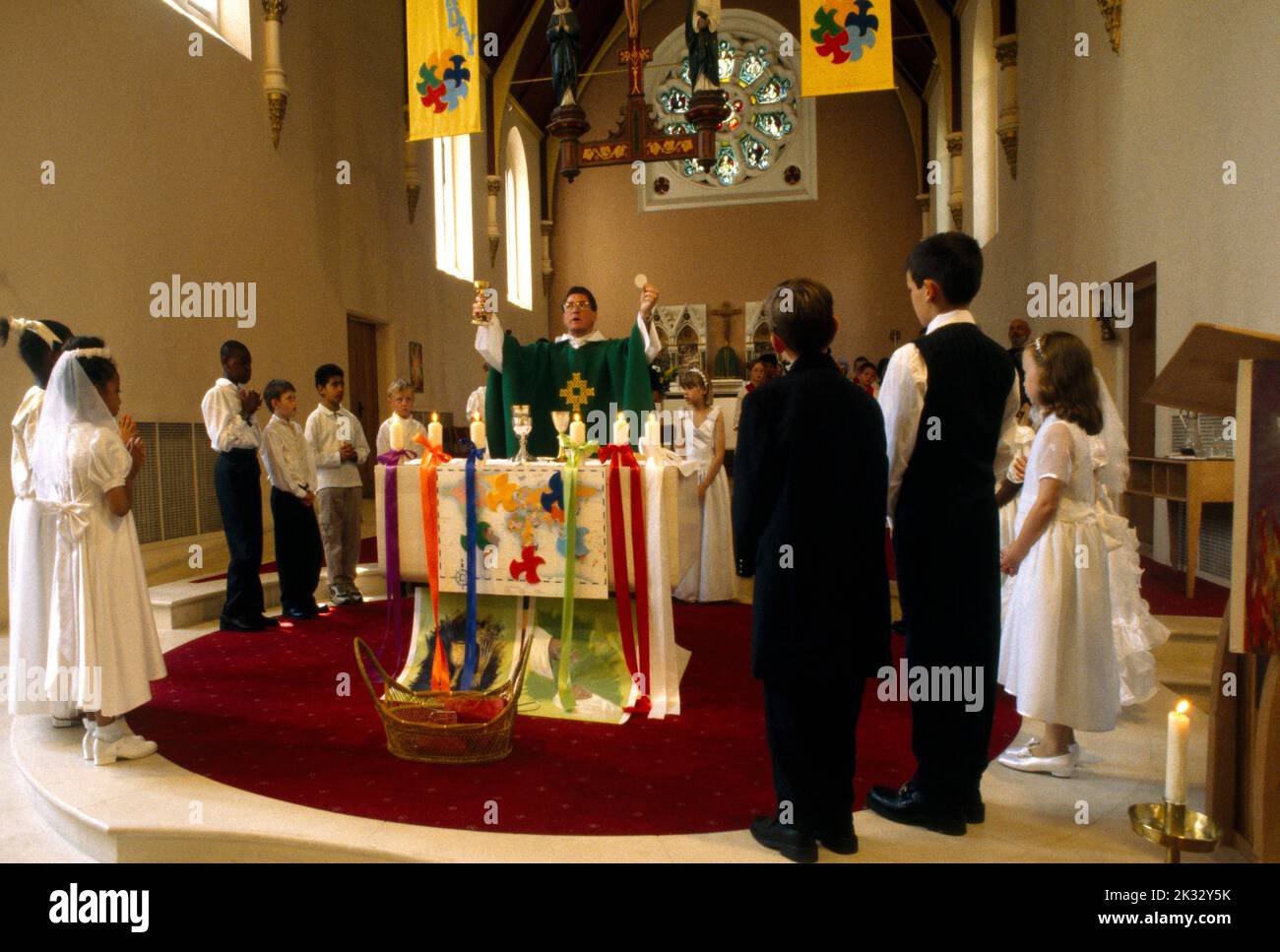 Priest at Altar performing the Eucharist at First Communion St Joseph's Church Roehampton London England Stock Photo