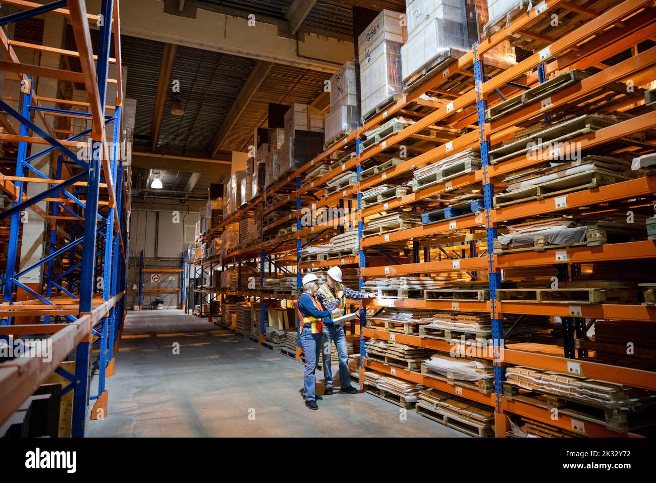Colleagues inspecting building materials in distribution warehouse