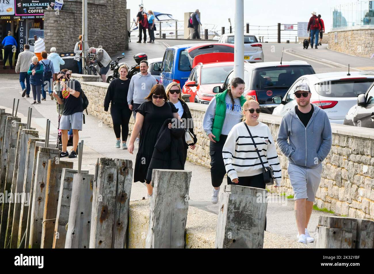 West Bay, Dorset, UK.  24th September 2022.  UK Weather.  The harbourside at the seaside resort of West Bay in Dorset is busy with visitors and locals enjoying the warm afternoon hazy autumn sunshine.  Picture Credit: Graham Hunt/Alamy Live News Stock Photo