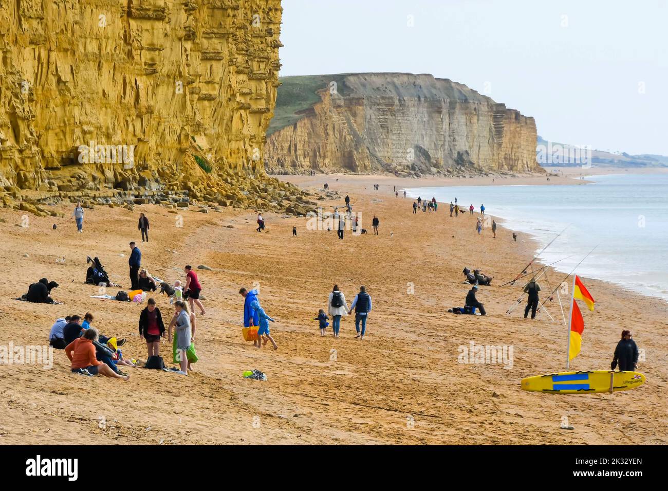 West Bay, Dorset, UK.  24th September 2022.  UK Weather.  The beach at the seaside resort of West Bay in Dorset is busy with visitors and locals enjoying the warm afternoon hazy autumn sunshine.  Picture Credit: Graham Hunt/Alamy Live News Stock Photo