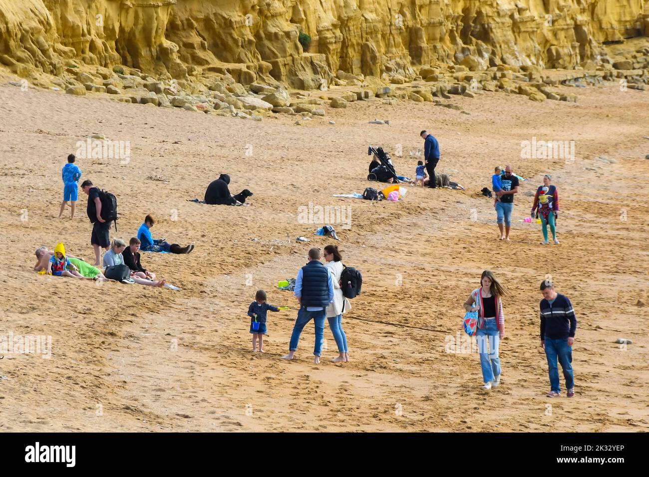 West Bay, Dorset, UK.  24th September 2022.  UK Weather.  The beach at the seaside resort of West Bay in Dorset is busy with visitors and locals enjoying the warm afternoon hazy autumn sunshine.  Picture Credit: Graham Hunt/Alamy Live News Stock Photo