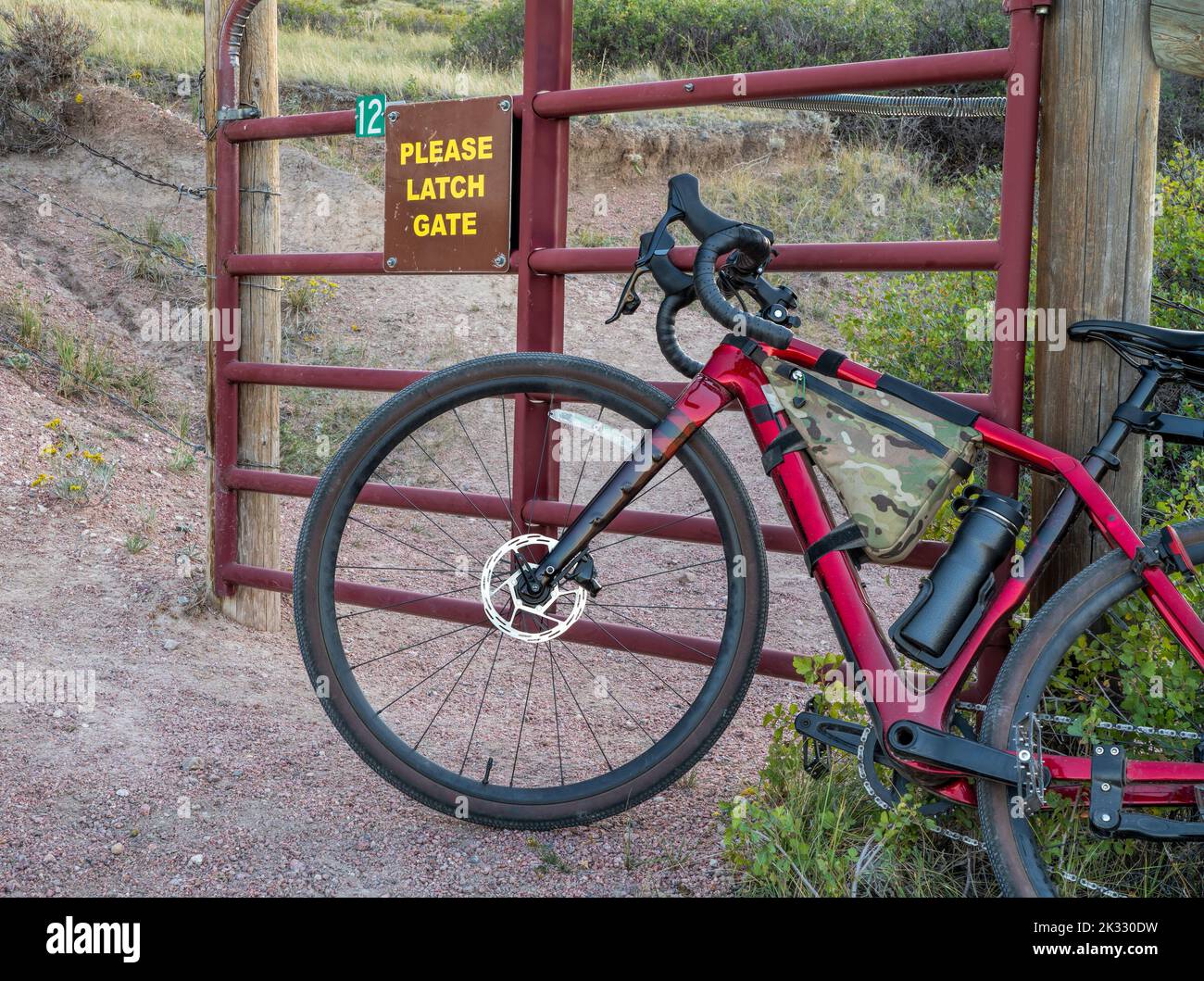 gravel bike at a cattle gate on a trail in Colorado foothills, Soapstone Prairie Natural Area Stock Photo