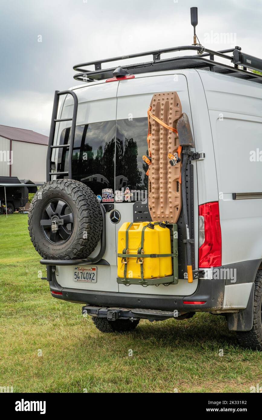 Loveland, CO, USA - August 26, 2022: Back of 4x4 camper van on Mercedes Sprinter chassis with a spare tire, diesel fuel containers and recovery ladder Stock Photo