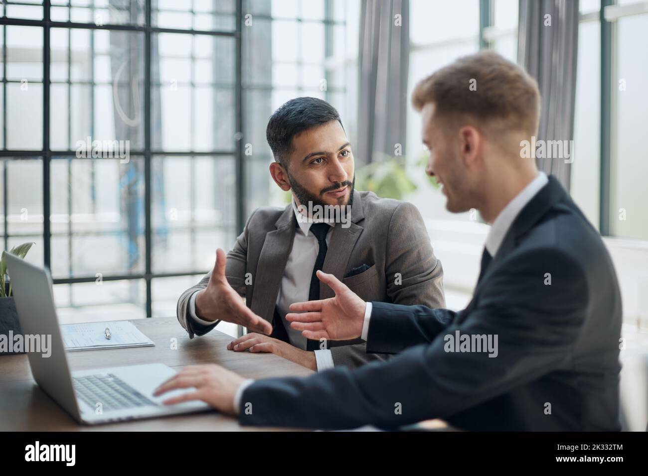 two professional businessmen discussing and using desktop computer in office Stock Photo