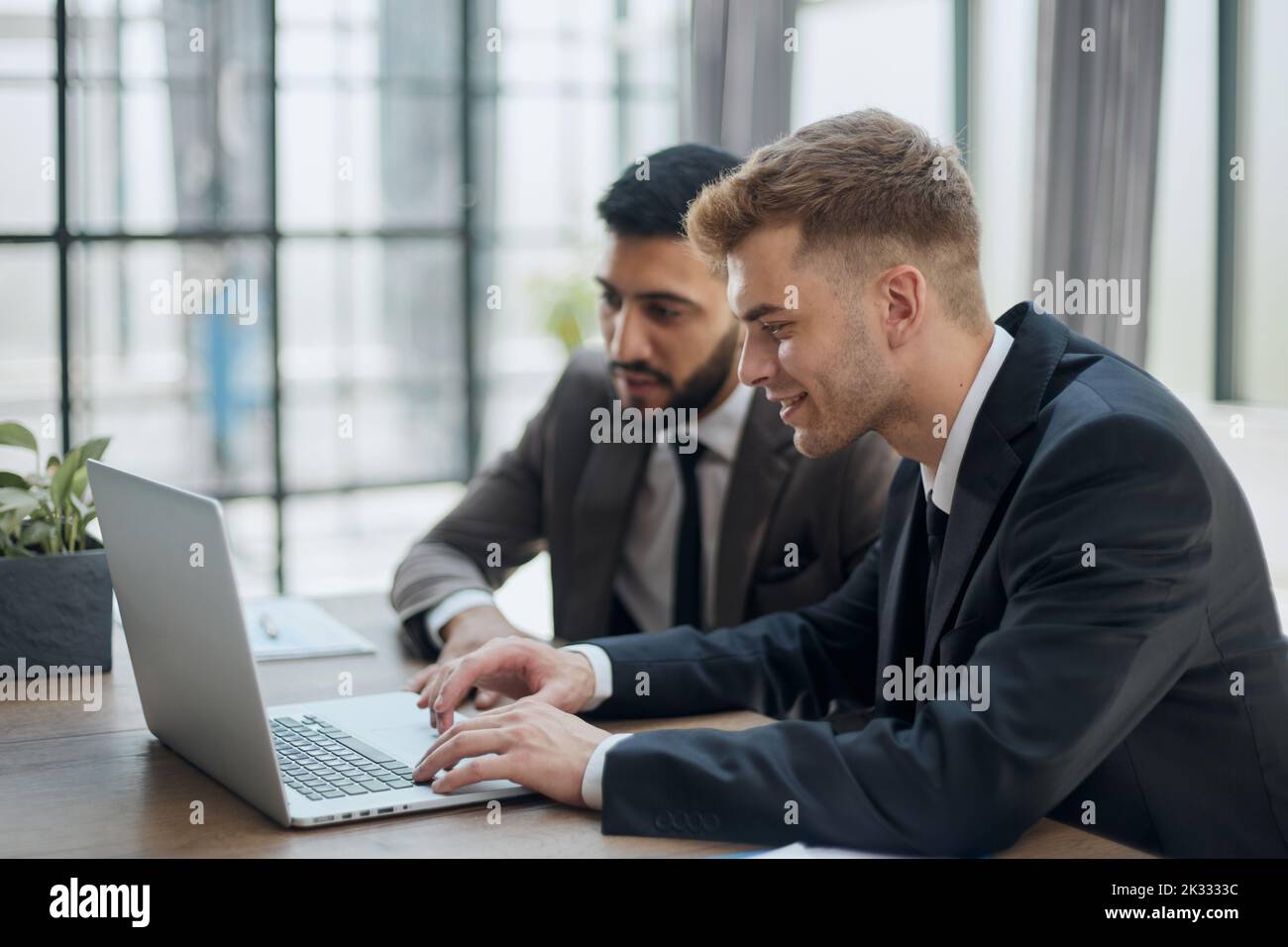 two professional businessmen discussing and using desktop computer in office Stock Photo
