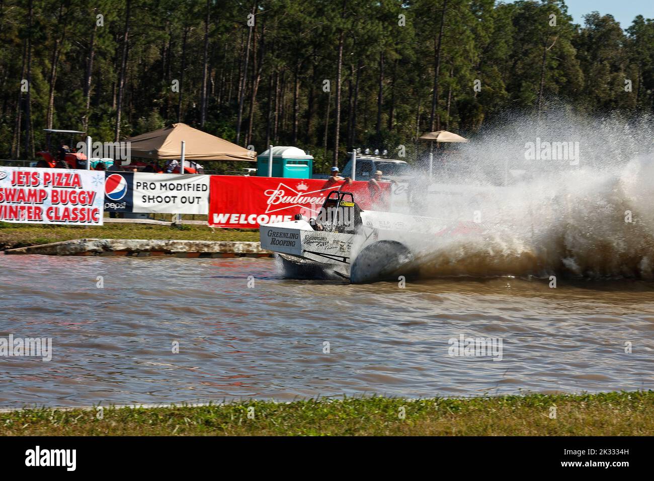 swamp buggy racing, very large water spray, action, advertising banners, spectators, contest, motion, sport, Florida Sports Park, Naples, FL Stock Photo