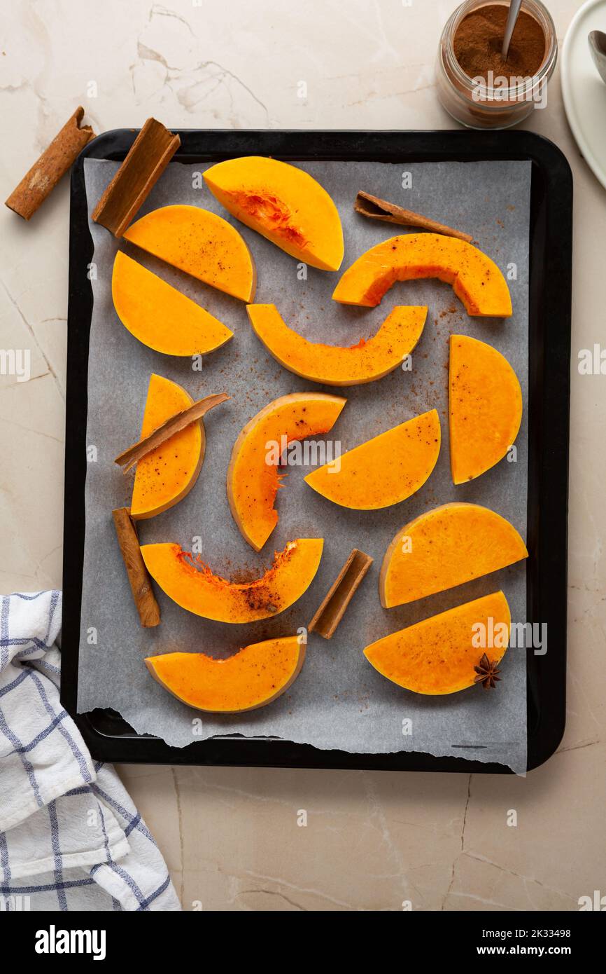 Pieces of pumpkin on a baking sheet ready for baking food top view Stock Photo