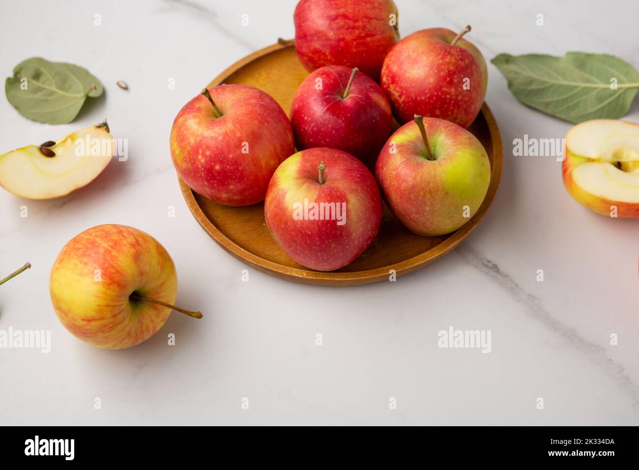 Close up of red yellow apples on wooden plate fruits food Stock Photo