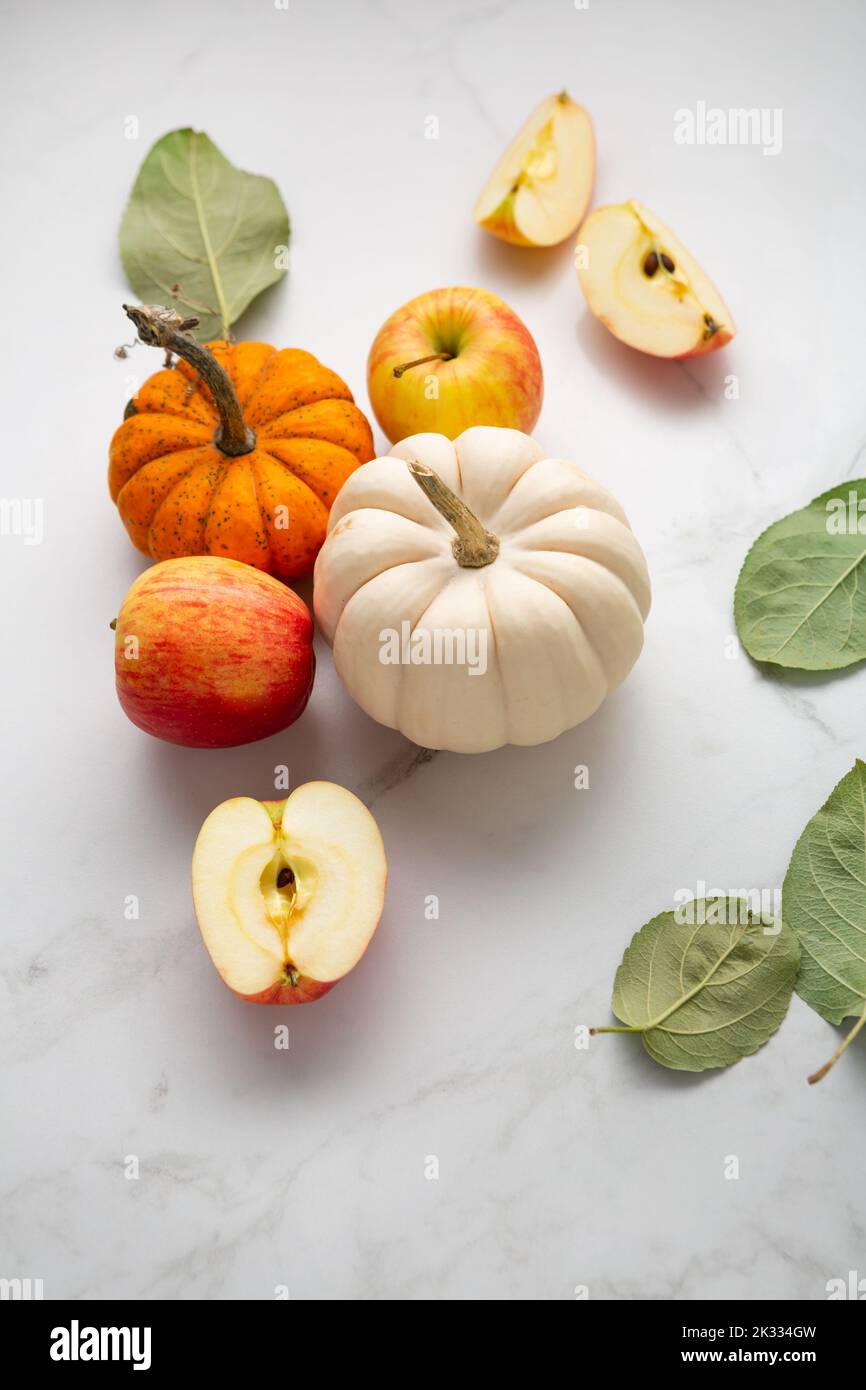 Small pumpkins and apples on light surface autumn concept food harvest Stock Photo