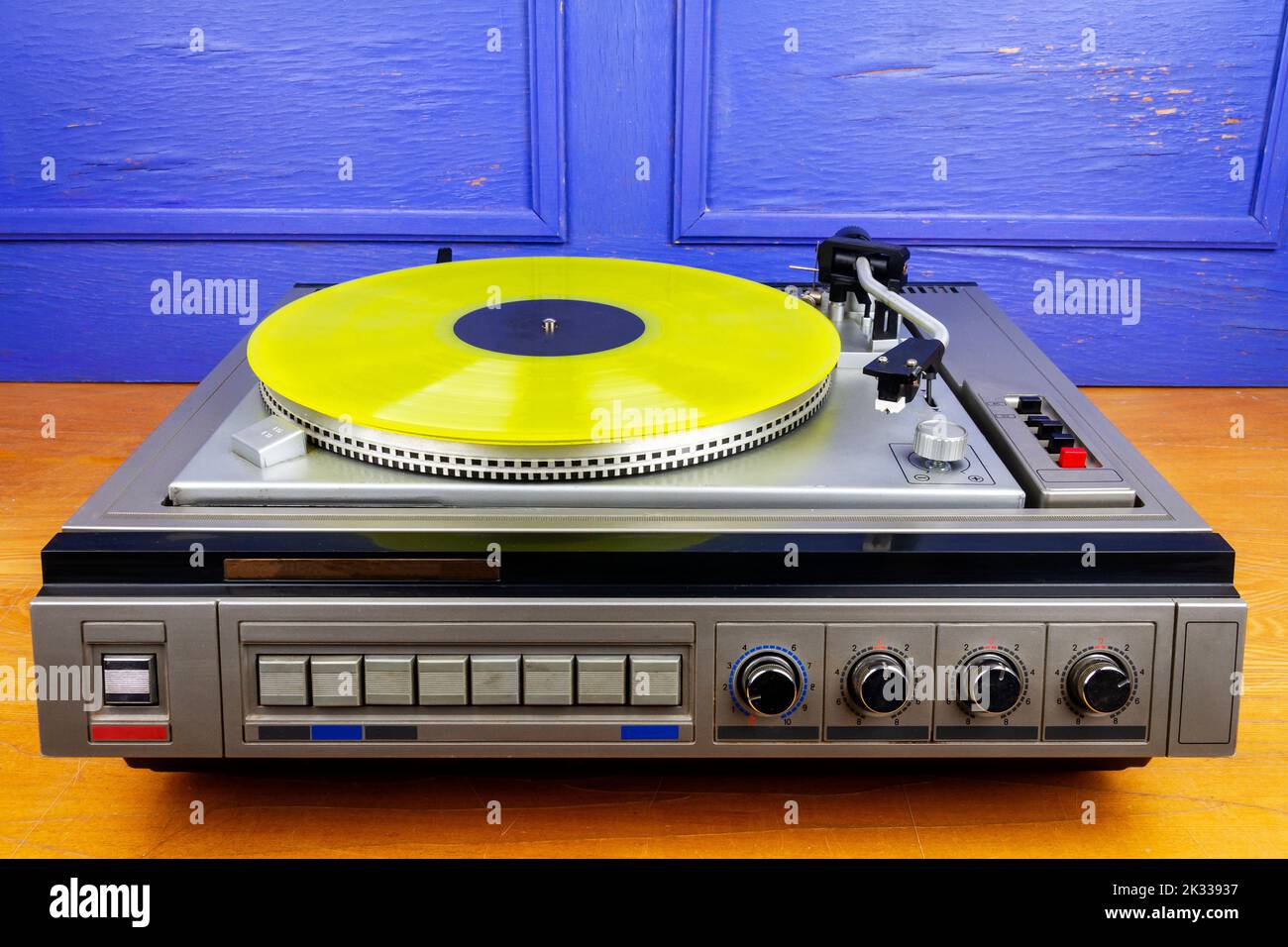 Vintage turntable vinyl record player with yellow vinyl on a table ...