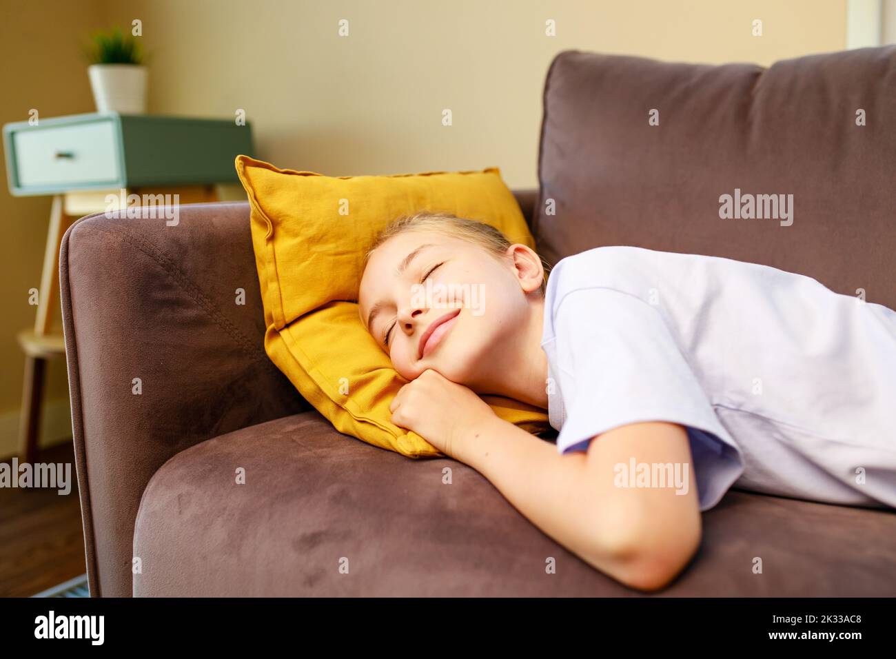 little cute girl sleeping on sofa after study in school daytime Stock