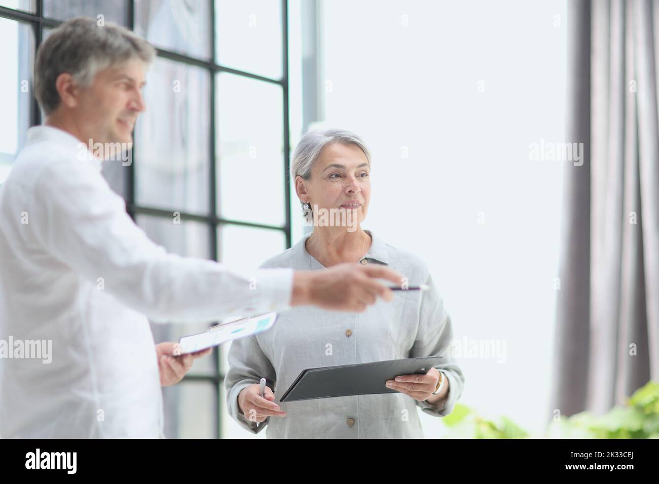 Businessman and woman working on computer together Stock Photo