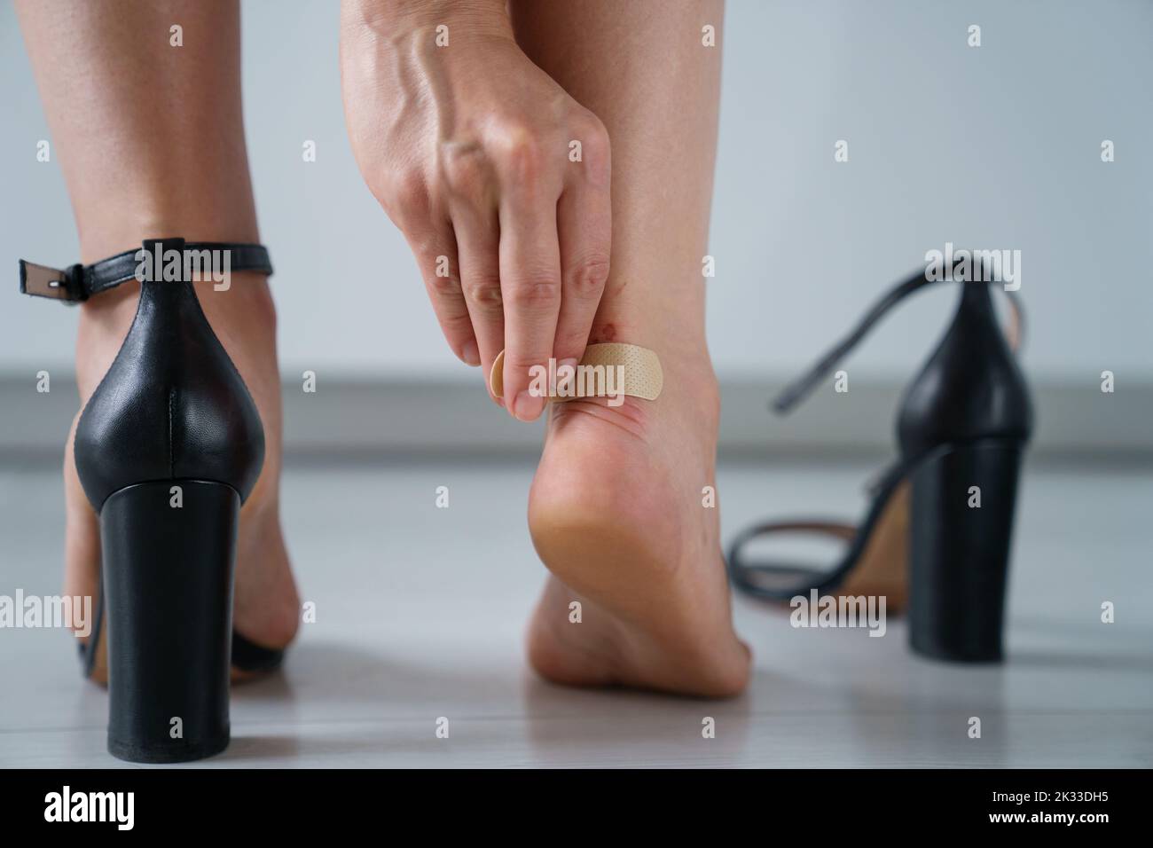 Bandaid on blister on leg. Woman having pain after wearing high heel