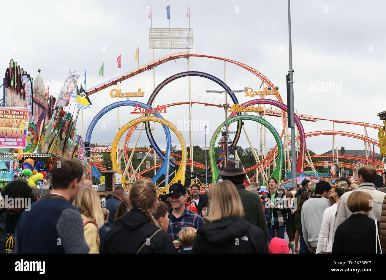 Munich, Germany. 24th Sep, 2022. Many visitors to the Oktoberfest walk  across the Theresienwiese near the five-loop roller coaster. The Wiesn  takes place from September 17 to October 3, 2022. Credit: Felix