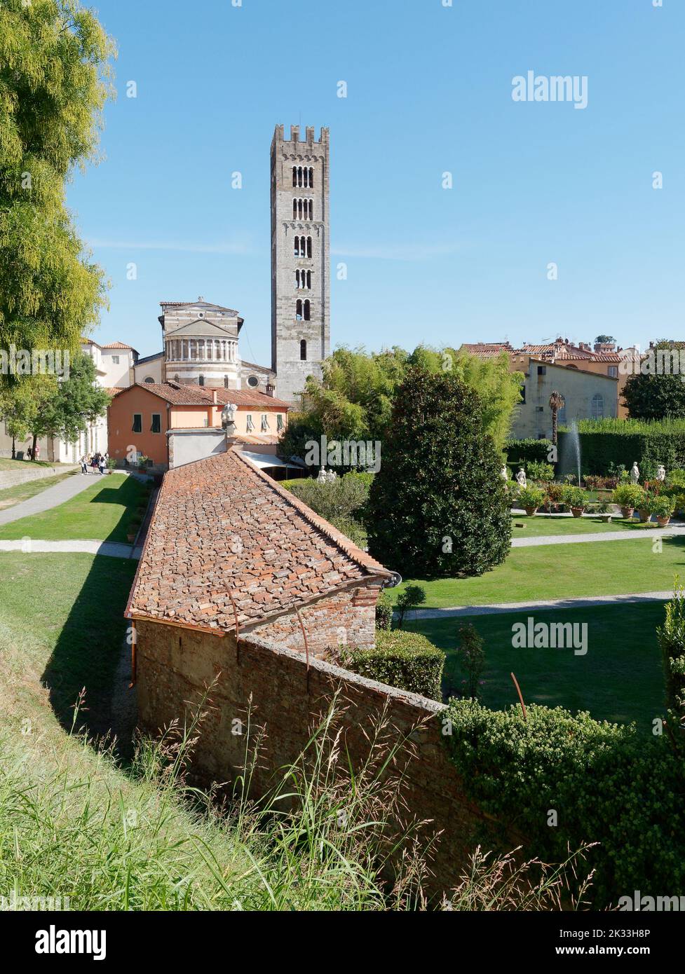 View from the wall (raised walkway left)in the centre of Lucca towards a tower. Tuscany, Italy. Stock Photo