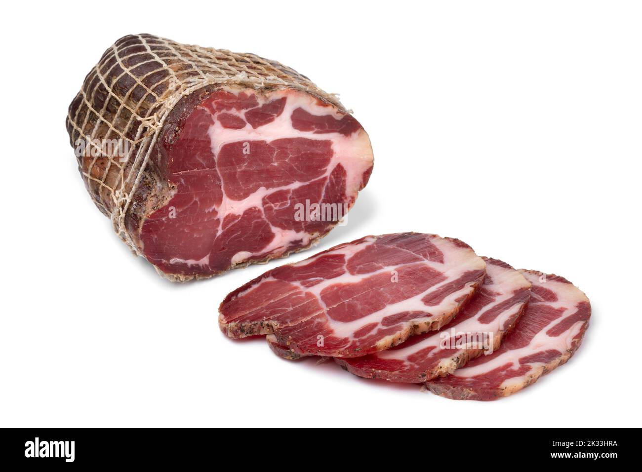 Piece and slices of traditional Croatian dried pork neck, pork collar bacon, close isolated up on white background Stock Photo