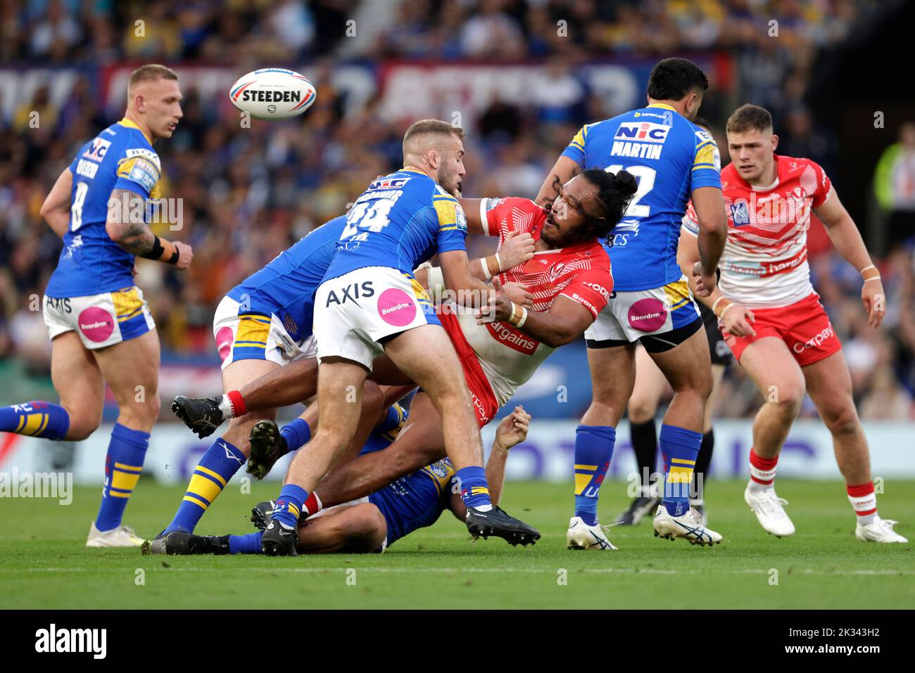 St Helens' Agnatius Paasi is tackled by Leeds Rhinos' Jarrod O'Connor (second left) during the Betfred Super League Grand Final at Old Trafford, Manchester. Picture date: Saturday September 24, 2022. Stock Photo