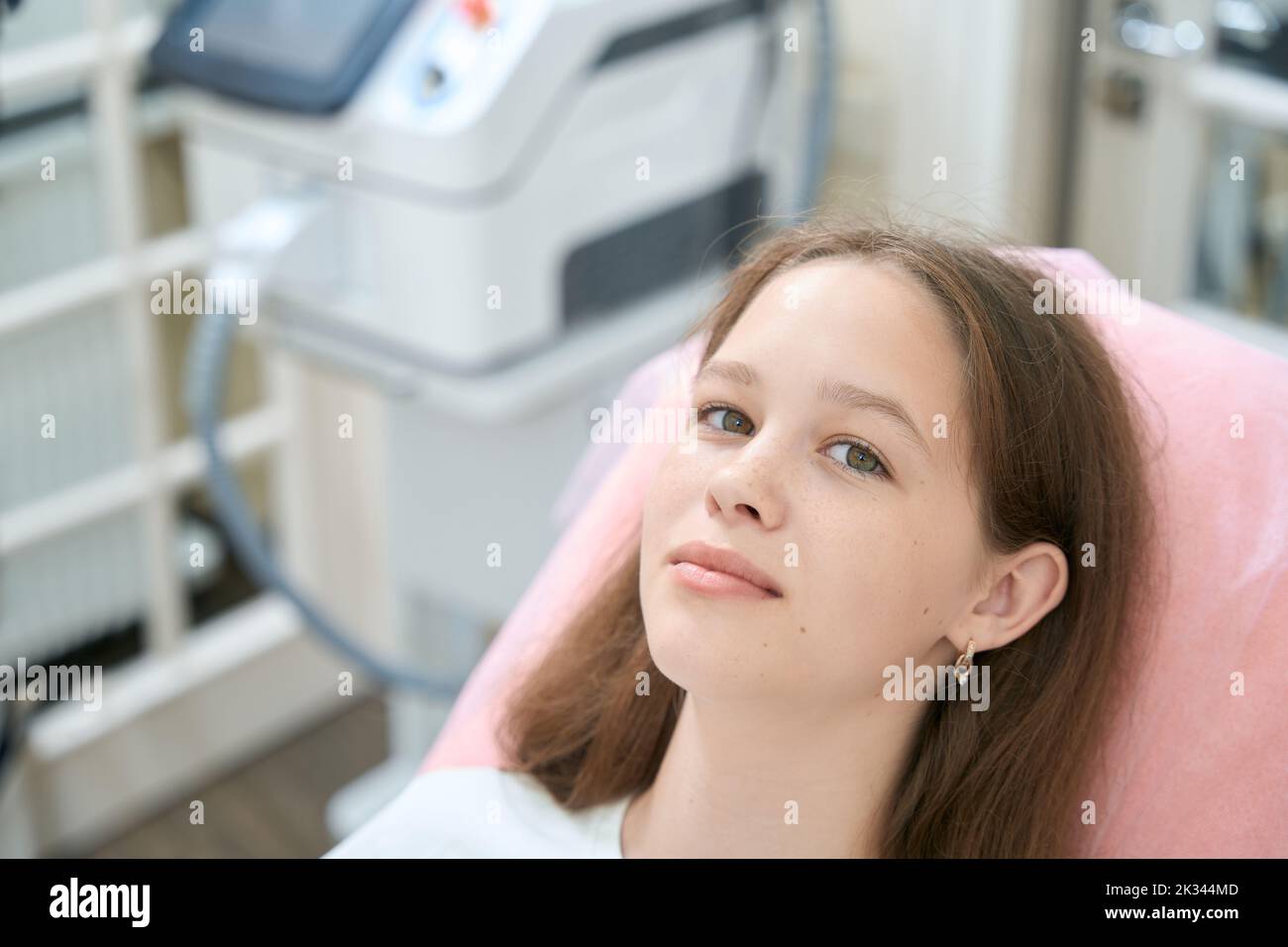 Teenage girl lies in chair in the beautician's office. Girl face close up Stock Photo