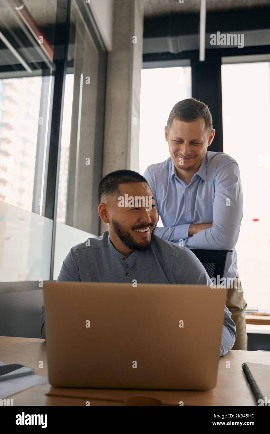 Joyful corporate worker and his pleased coworker in workplace Stock Photo