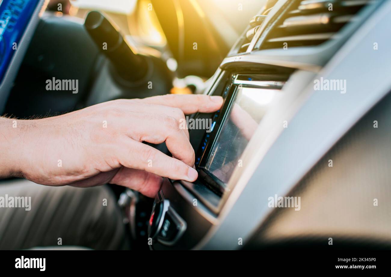 Close up of hands changing the car radio station. Concept of driver