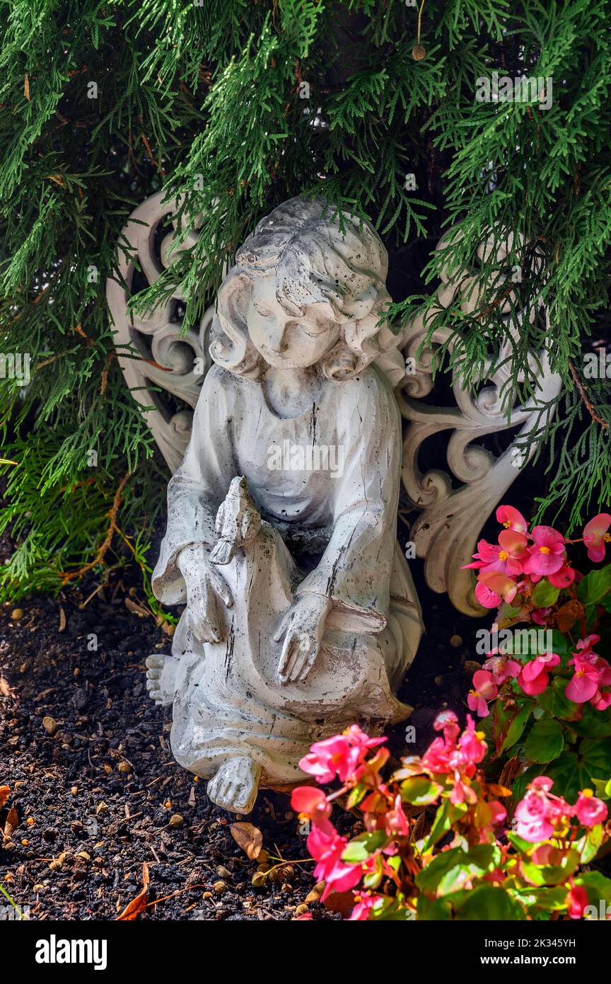 Grave with angel and flower decoration in Betzigau, Allgaeu, Bavaria, Germany Stock Photo