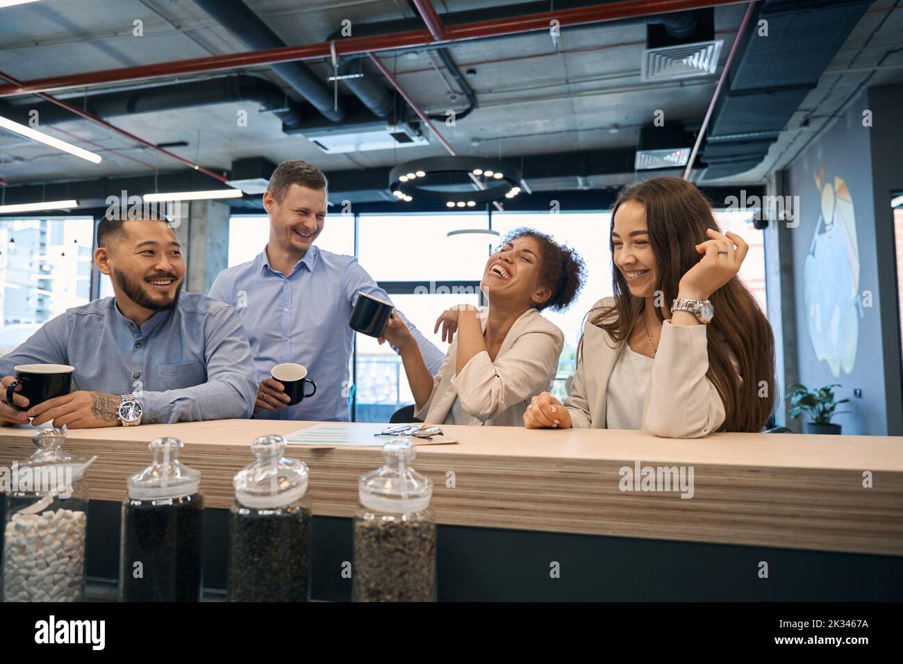 Cheerful company workers spending their coffee break together Stock Photo