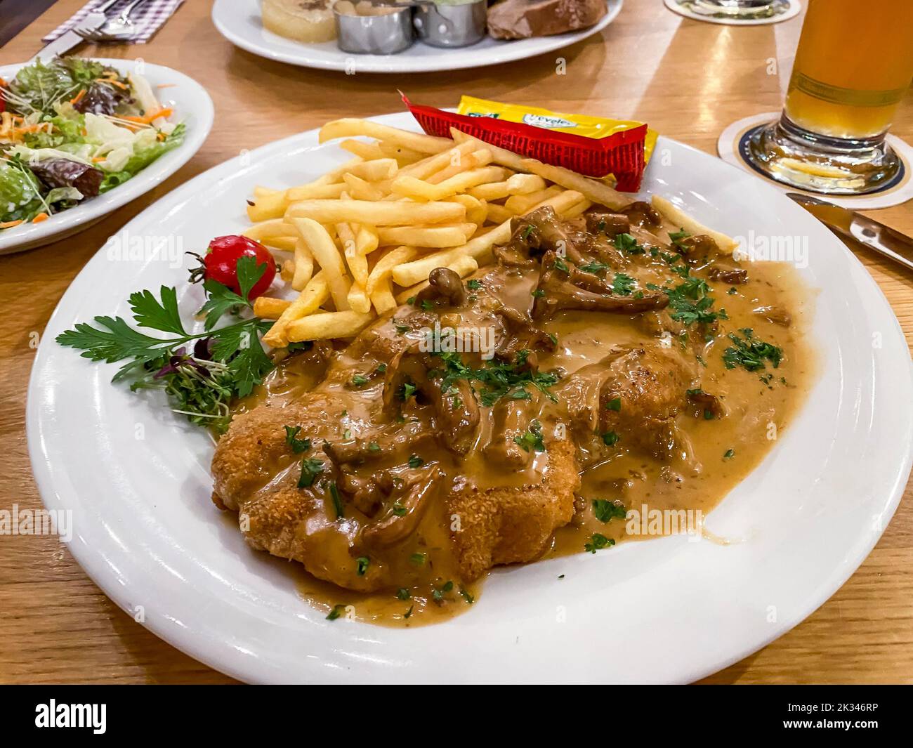 Creamed schnitzel with chanterelles, French fries, ketchup, mayonnaise, parsley, Hesse, Germany Stock Photo