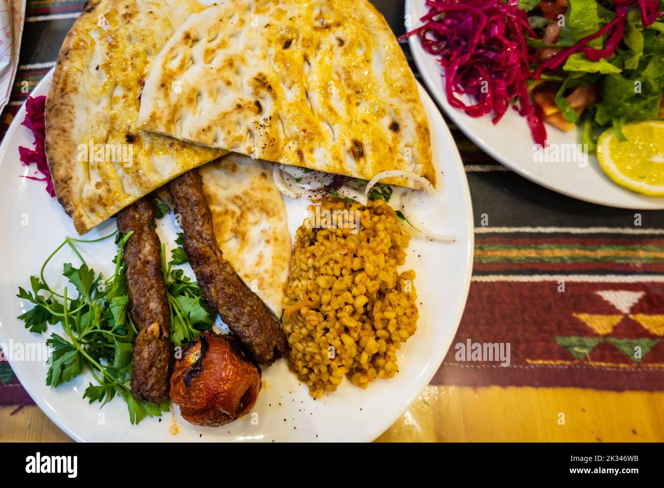 Urfa Kebab, traditional Turkish cuisine with kebab meat, vegetables on the plate in Sanliurfa, Turkey Stock Photo